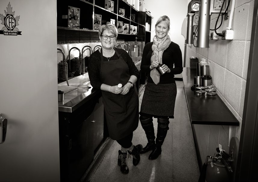 Kristin Duff (left) and Darcy Jordan (right) pose in SAIT's darkroom. Both women are accomplished photographers.